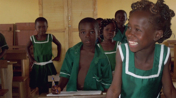 Students smile in a classroom in Africa.